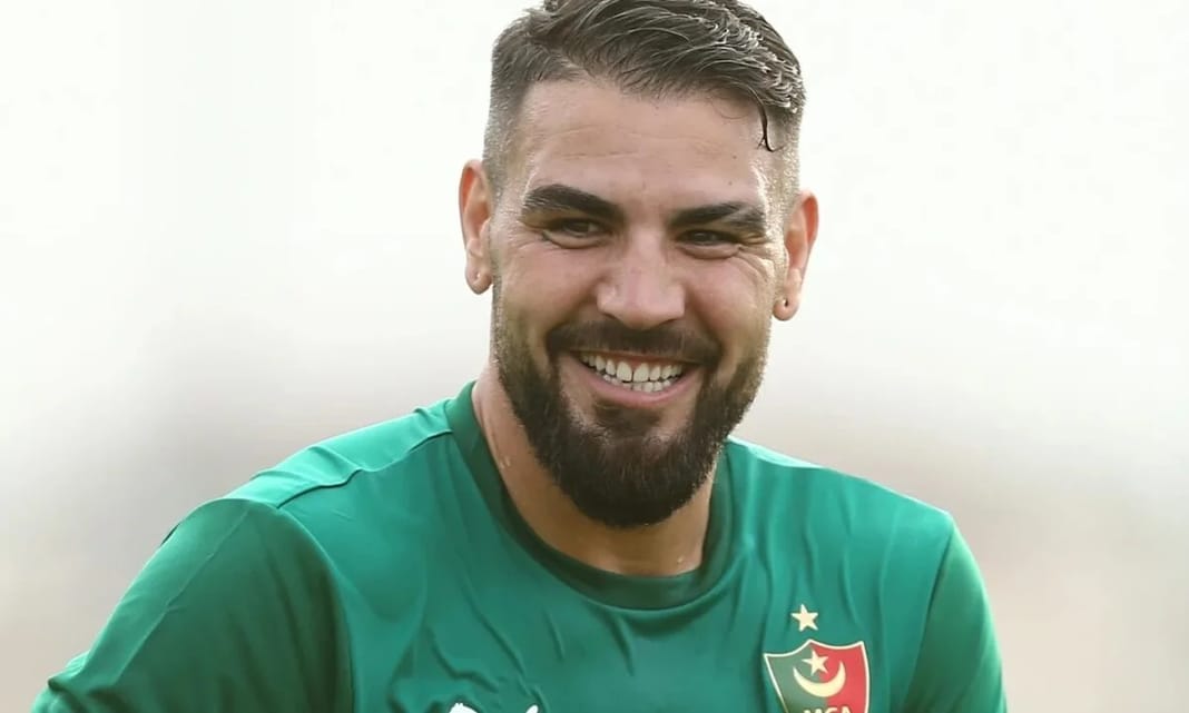 Andy Delort souriant en maillot vert du MCA lors d'un match.