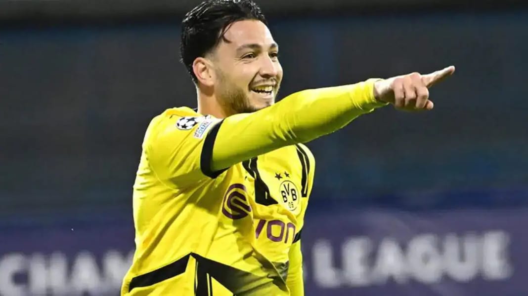 Joueur de football en jaune pointant du doigt.