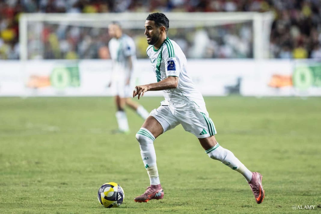 Riyad Mahrez en action lors d'un match Riyad Mahrez dribble le ballon lors d'un match de football.