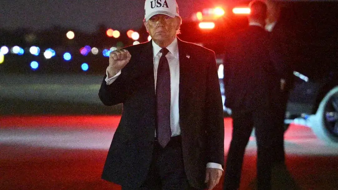 Donald Trump portant un chapeau 'USA' lors d'une sortie nocturne.