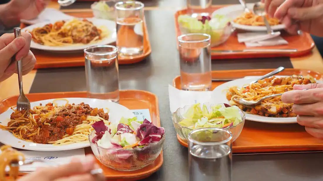 Repas de pâtes et salade dans un restaurant étudiant en Algérie.