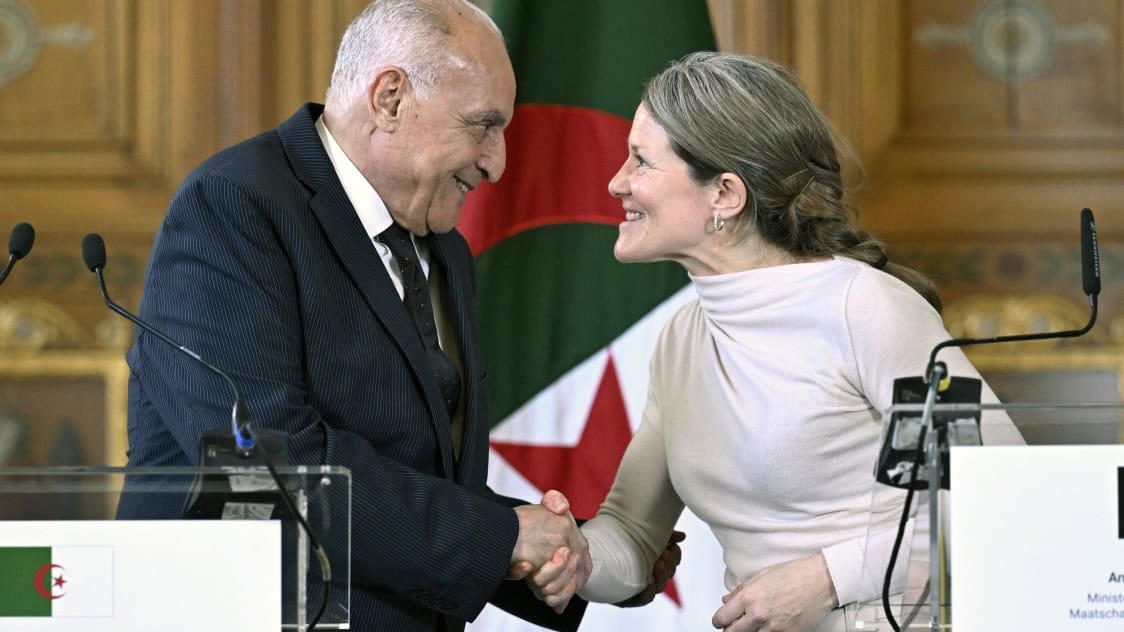 Deux dirigeants se serrent la main lors d'une réunion officielle.