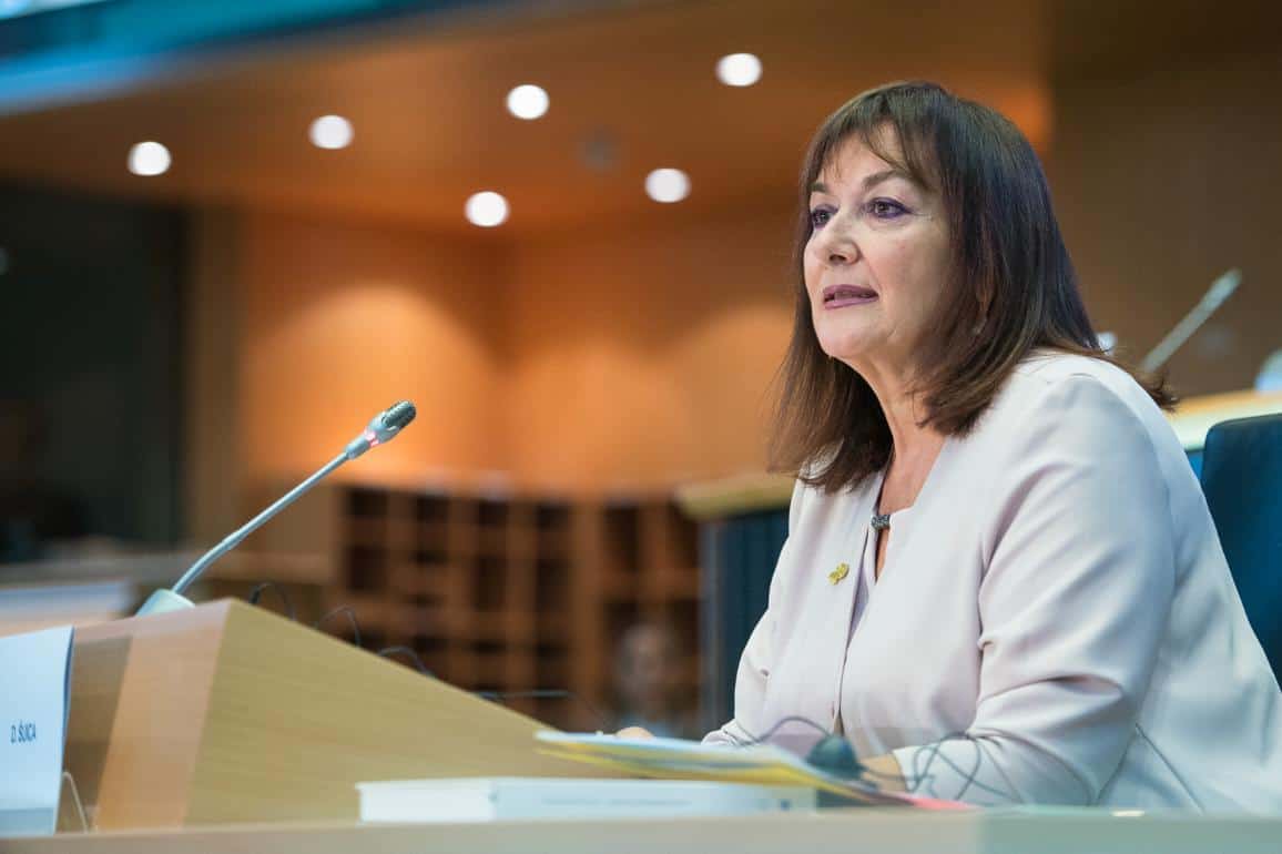Femme politique en discussion lors d'une réunion officielle.