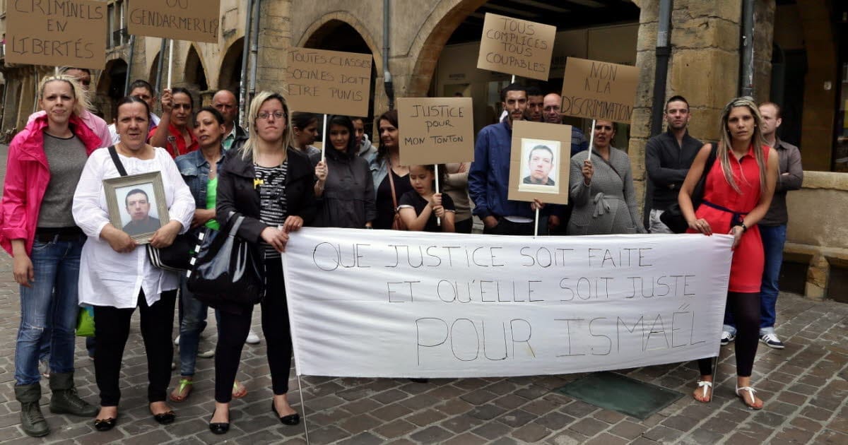Manifestants à Alger tenant des pancartes et photos lors d'une manifestation.