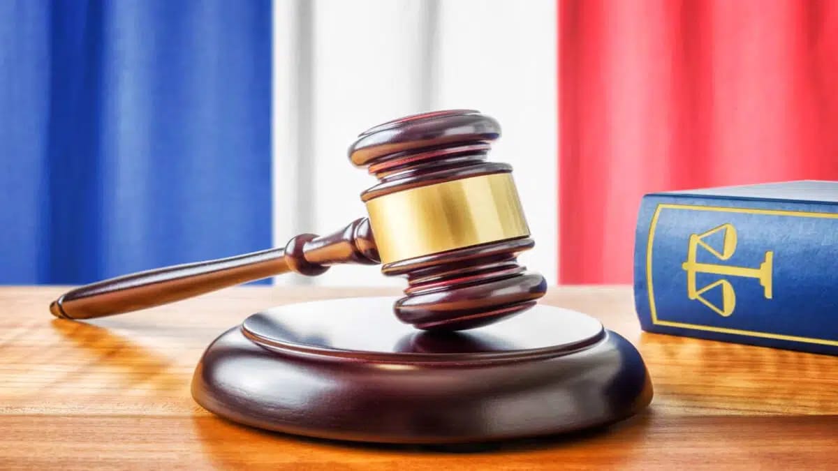 Marteau de juge et livre de droit sur une table en bois.
