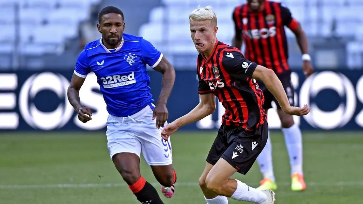 Joueur de Rangers en action contre un adversaire d'AC Milan.