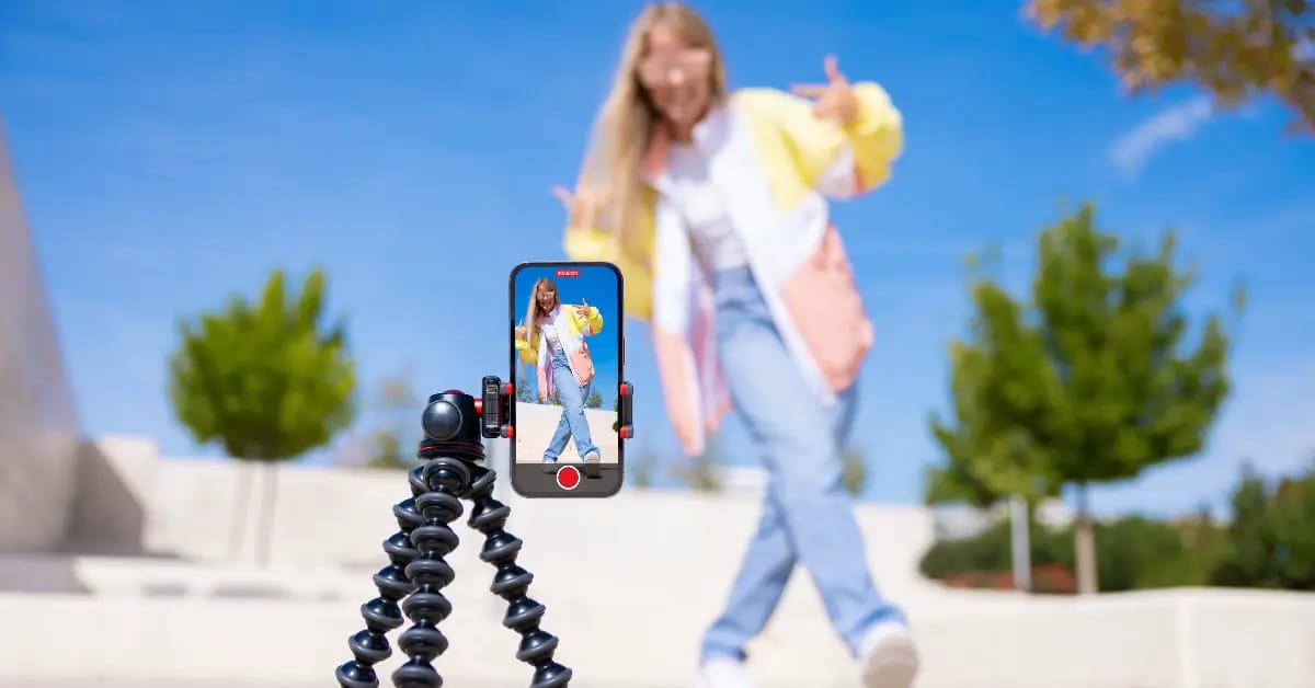 Jeune femme prenant une vidéo TikTok en extérieur avec un smartphone.