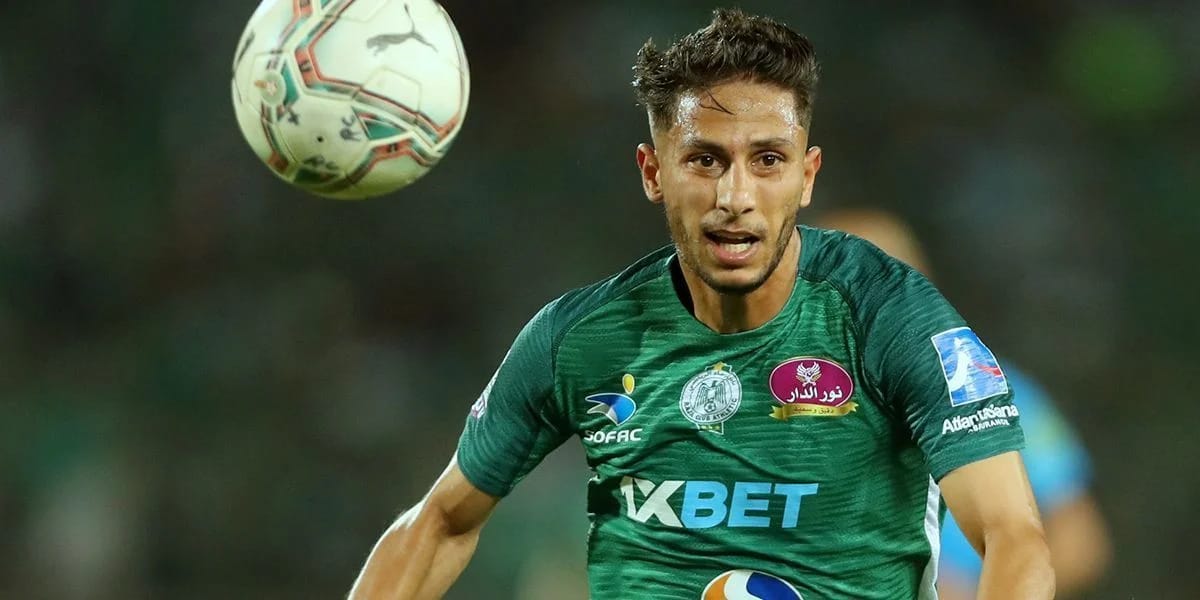 Youssri Bouzok lors d'un match de football, concentré et en mouvement.