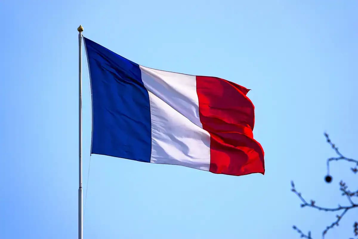 Drapeau français flottant dans le ciel bleu clair.