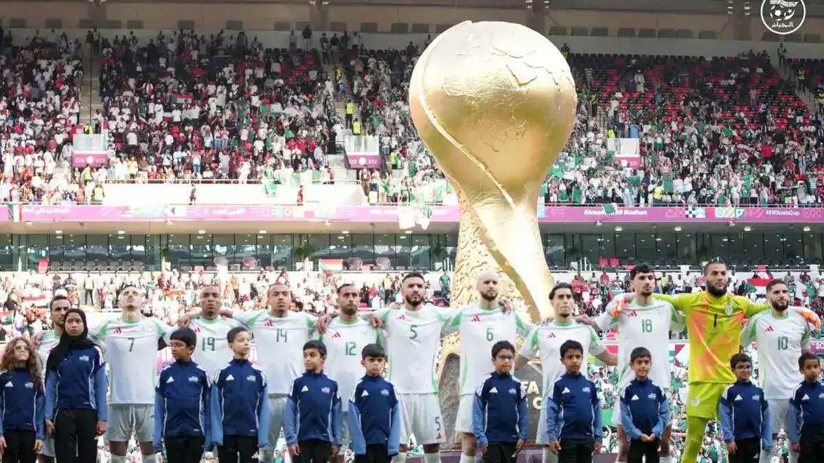 L'équipe algérienne de football avec la Coupe du Monde en tribune.
