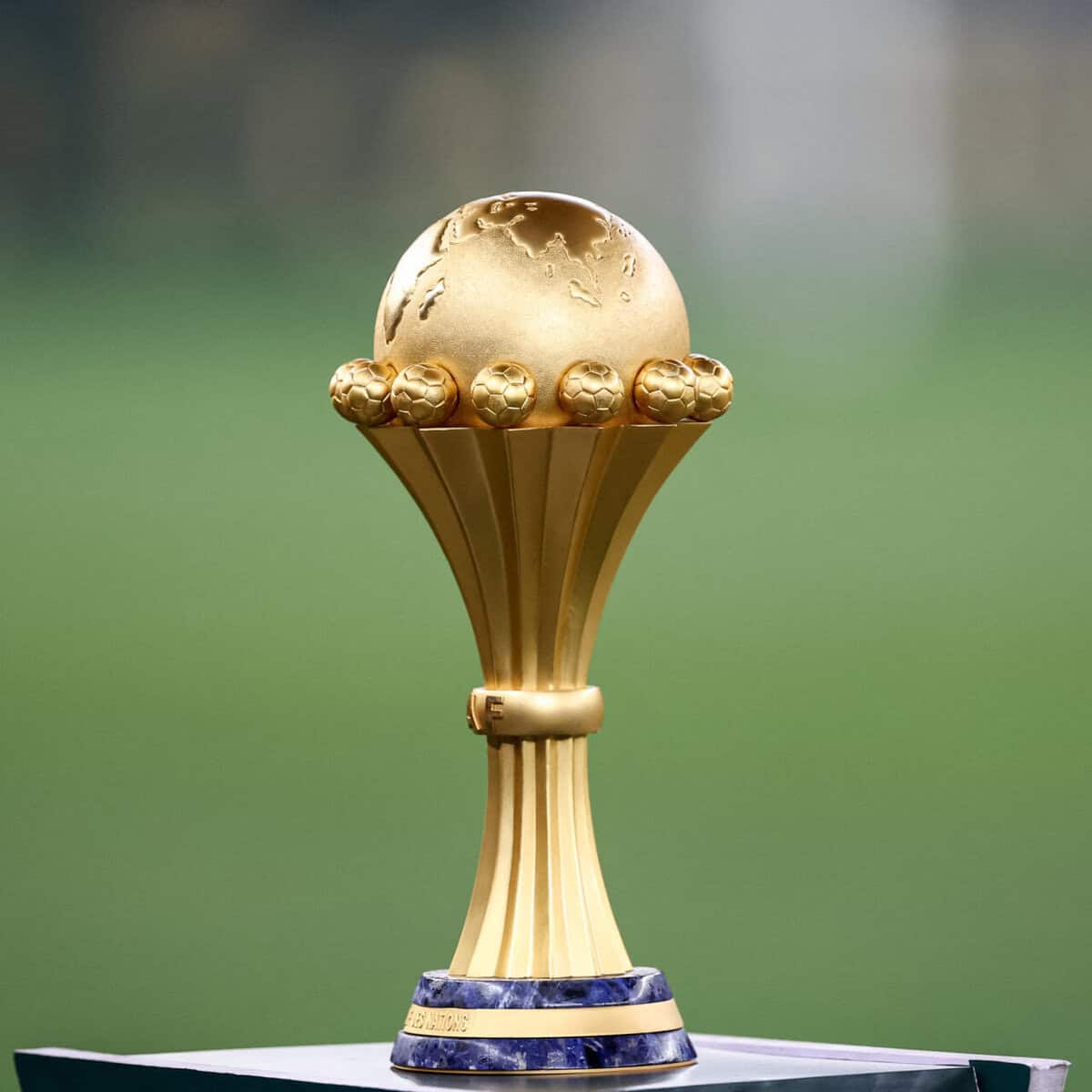 Trophée doré de la CAN 2025 avec globe terrestre en haut.