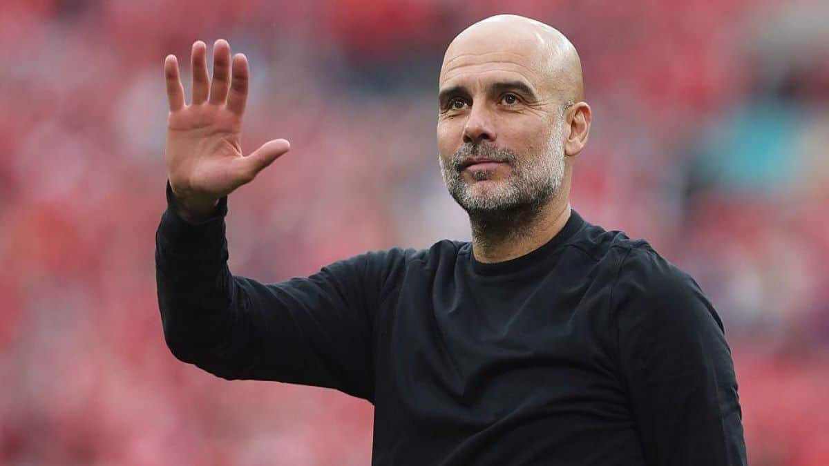 Pep Guardiola, entraîneur de football, saluant le public lors d'un match.