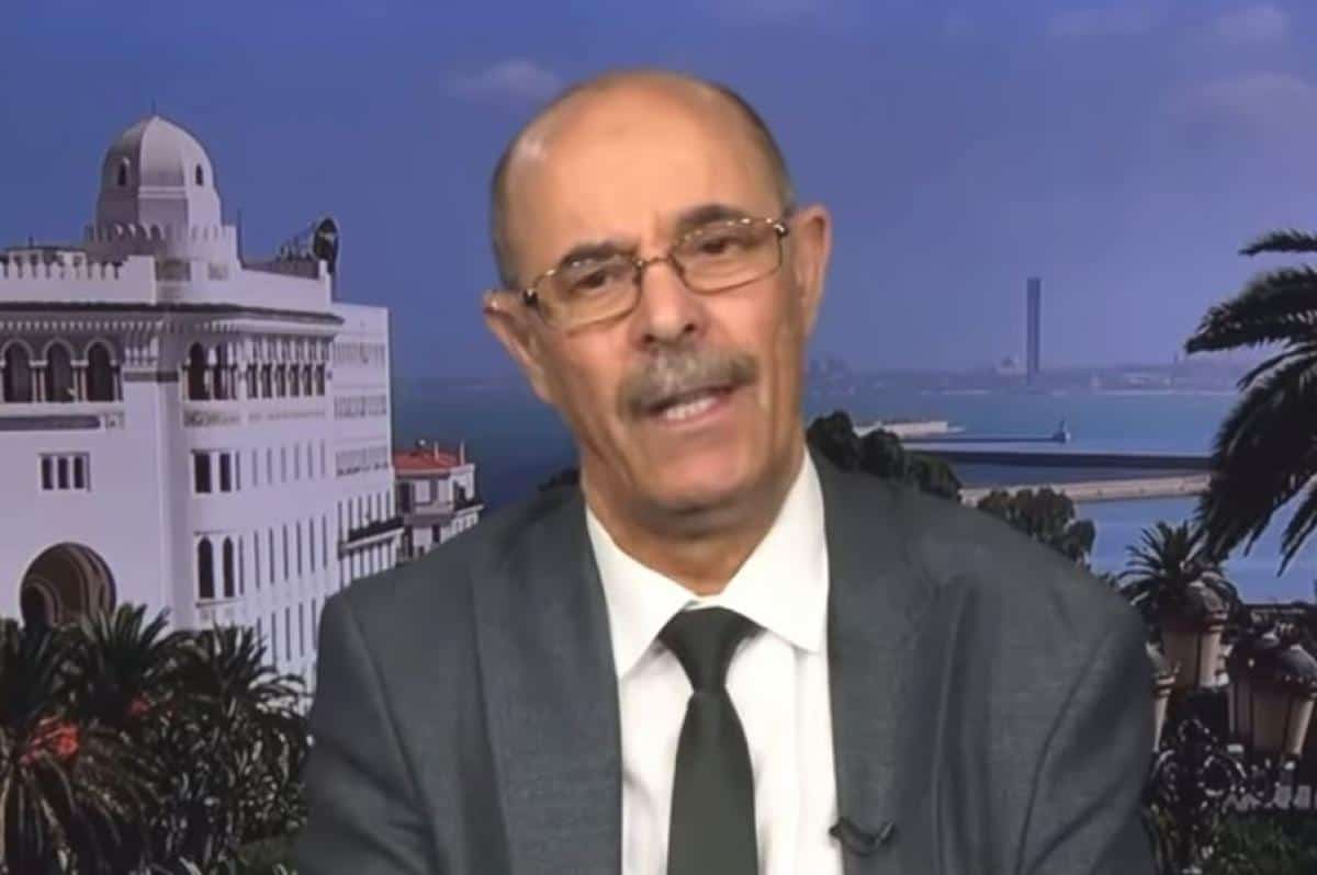 Mohamed Belghit lors d'une interview avec un décor urbain en arrière-plan.