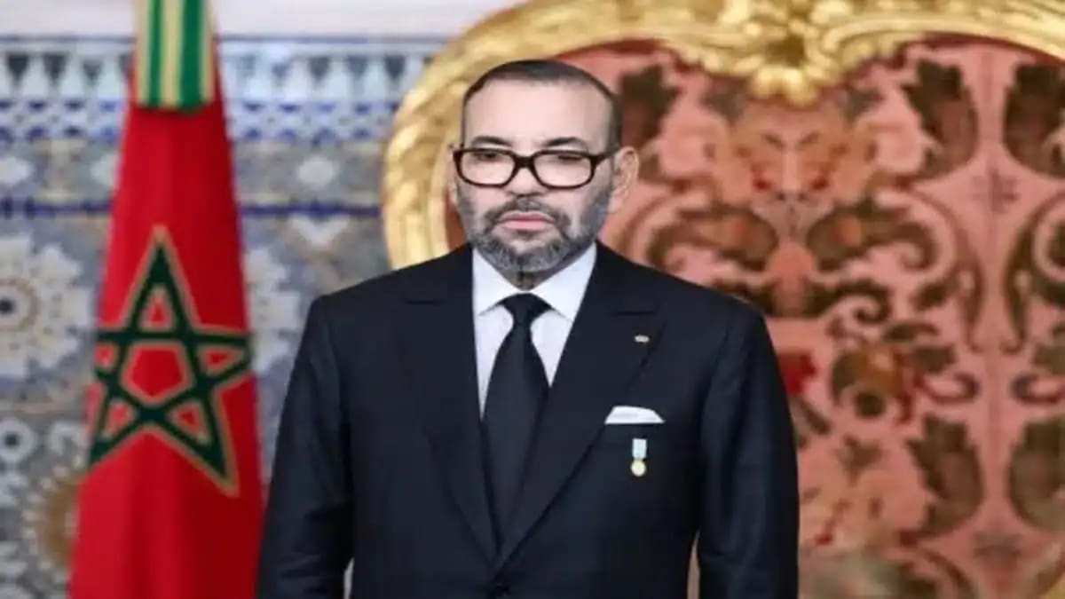 Mohammed VI en costume noir lors d'une cérémonie royale au Maroc.