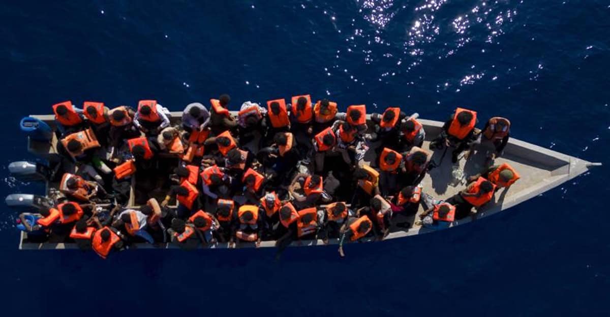 Migrants en mer à bord d'une embarcation sur l'océan.