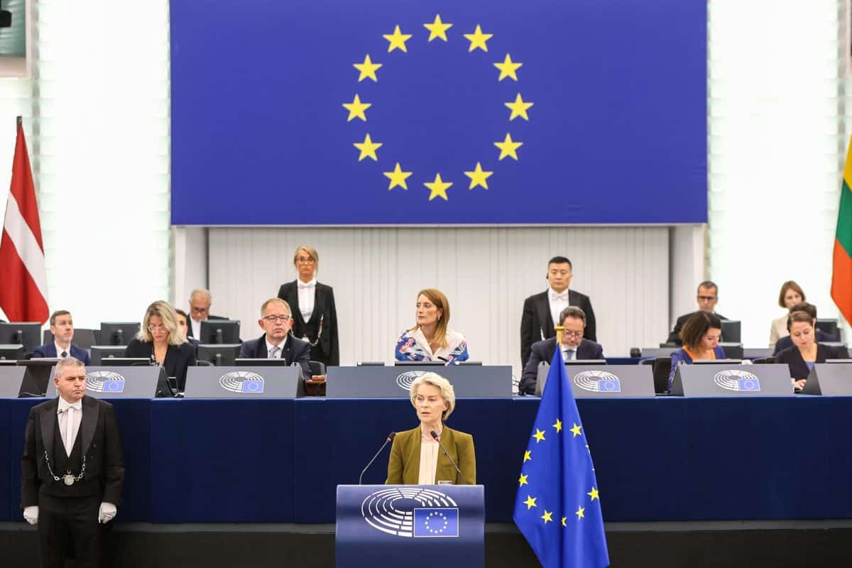 Parlement européen avec drapeau de l'UE et députés en session.
