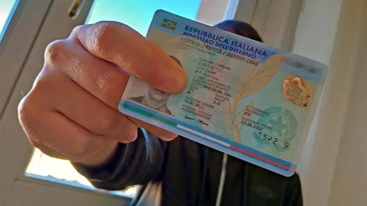 Personne tenant un permis de conduire italien avec fond clair.