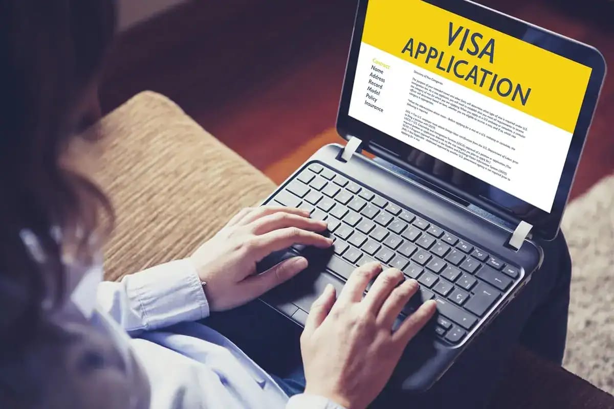 Personne utilisant un ordinateur pour remplir une demande de visa en ligne.