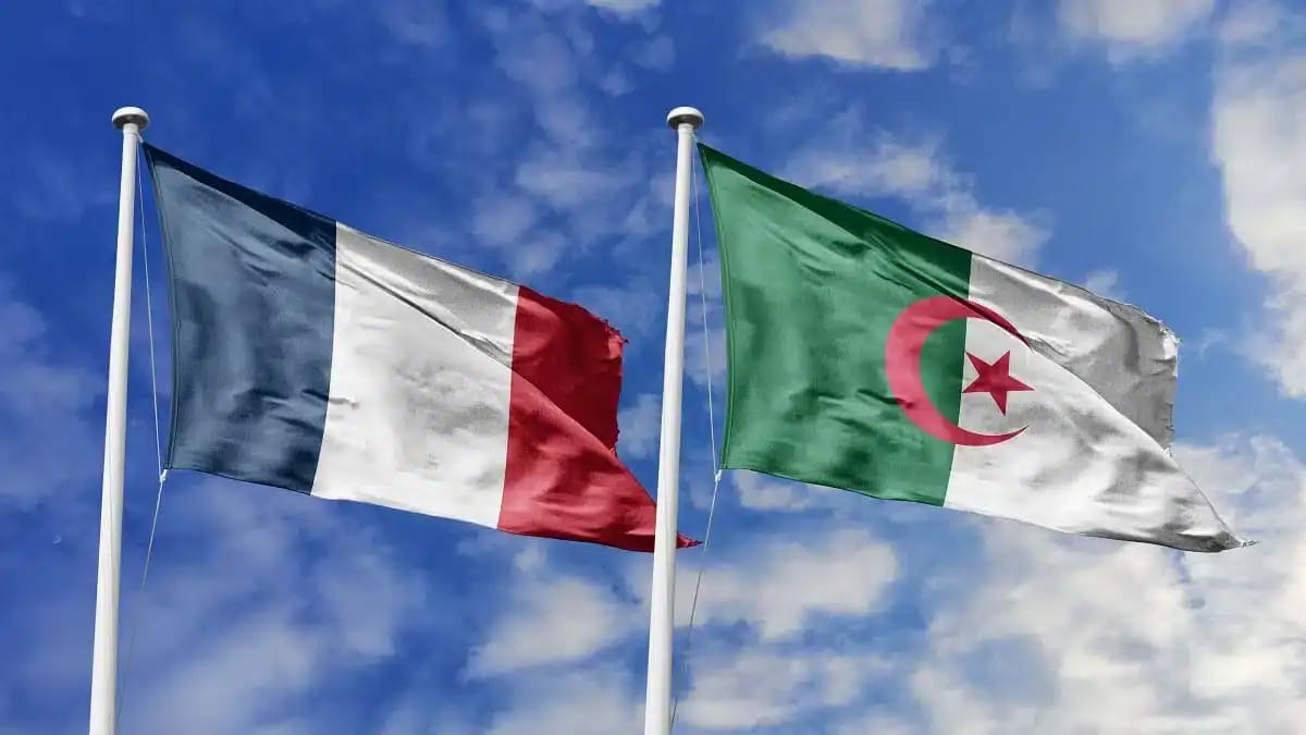 Drapeaux de la France et de l'Algérie flottant dans le ciel.