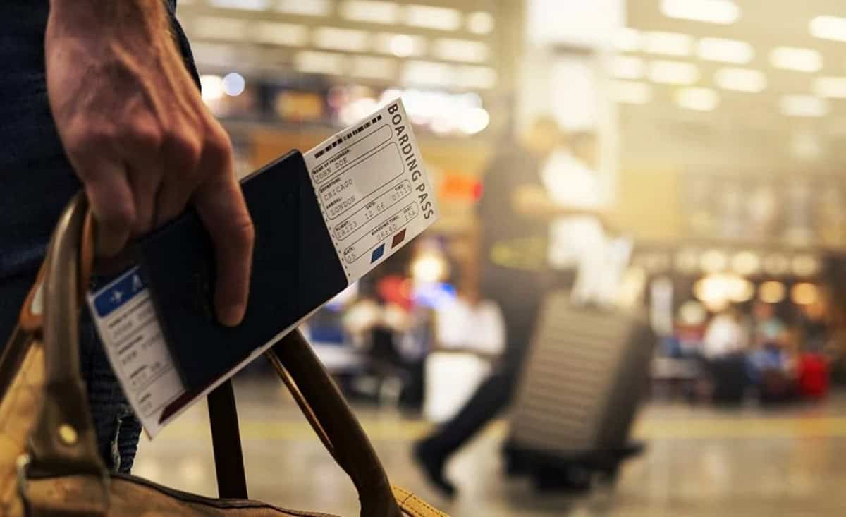 Passager tenant un billet d'embarquement à l'aéroport.