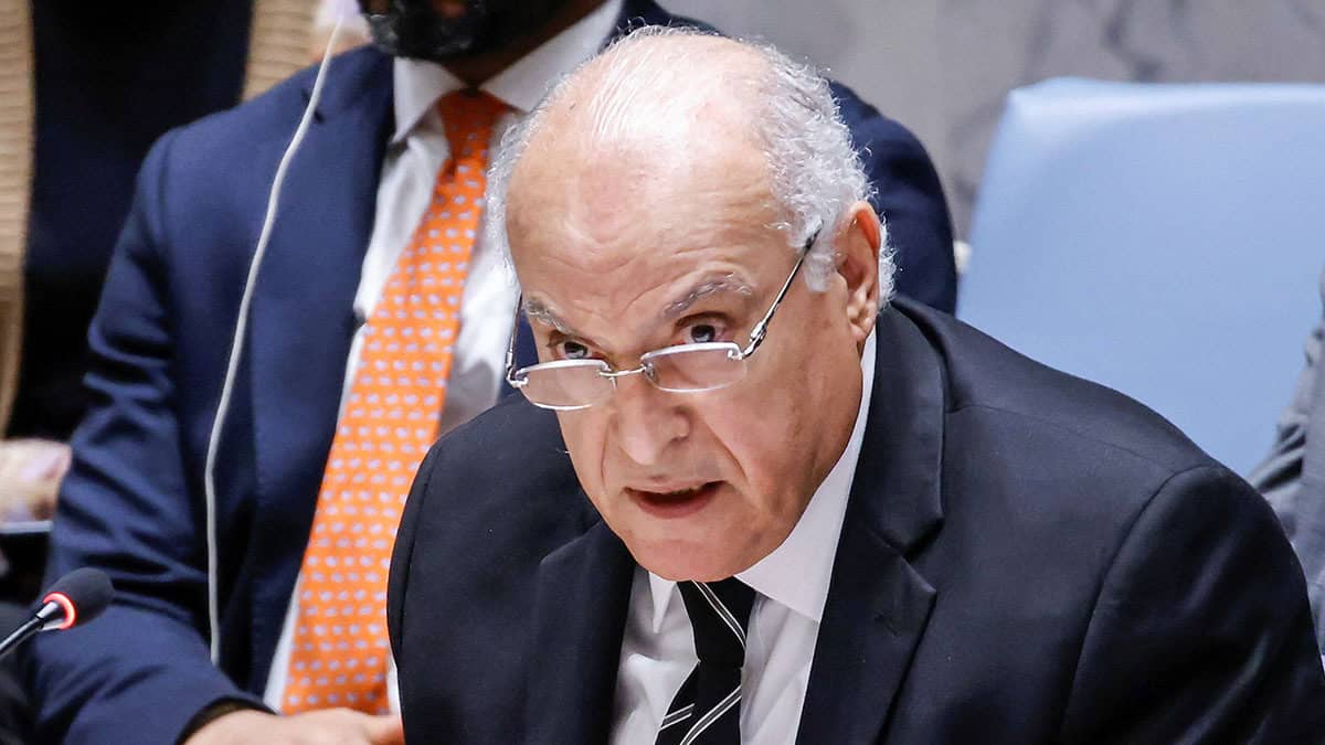 Homme âgé en costume lors d'une réunion diplomatique.
