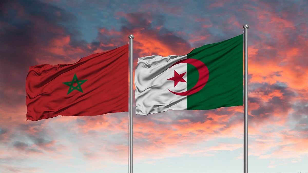 Drapeaux du Maroc et de l'Algérie flottant au coucher du soleil.
