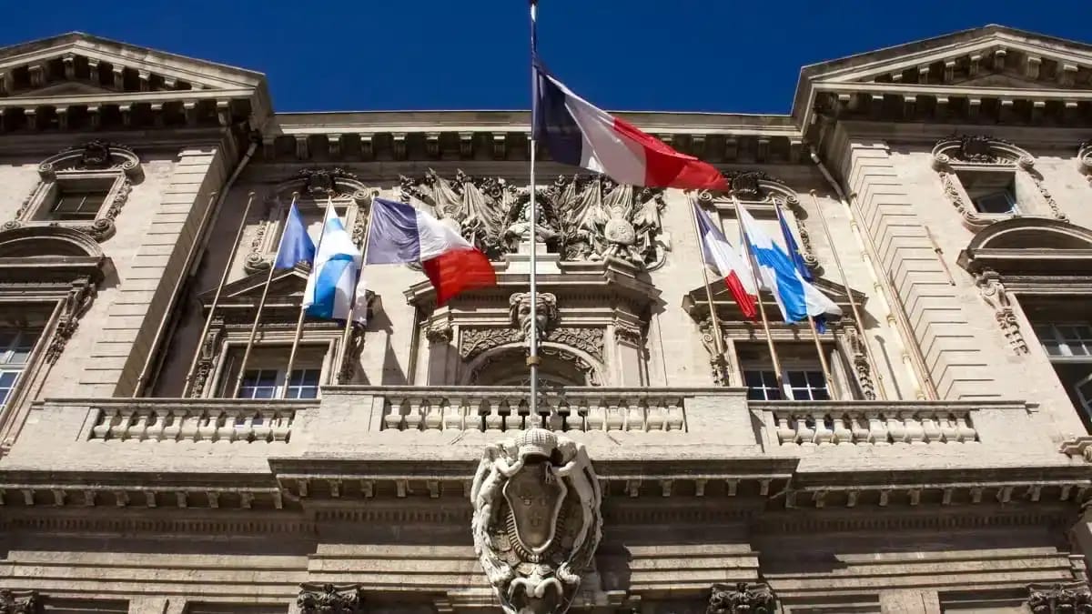 Bâtiment officiel en France avec drapeaux français et européens.