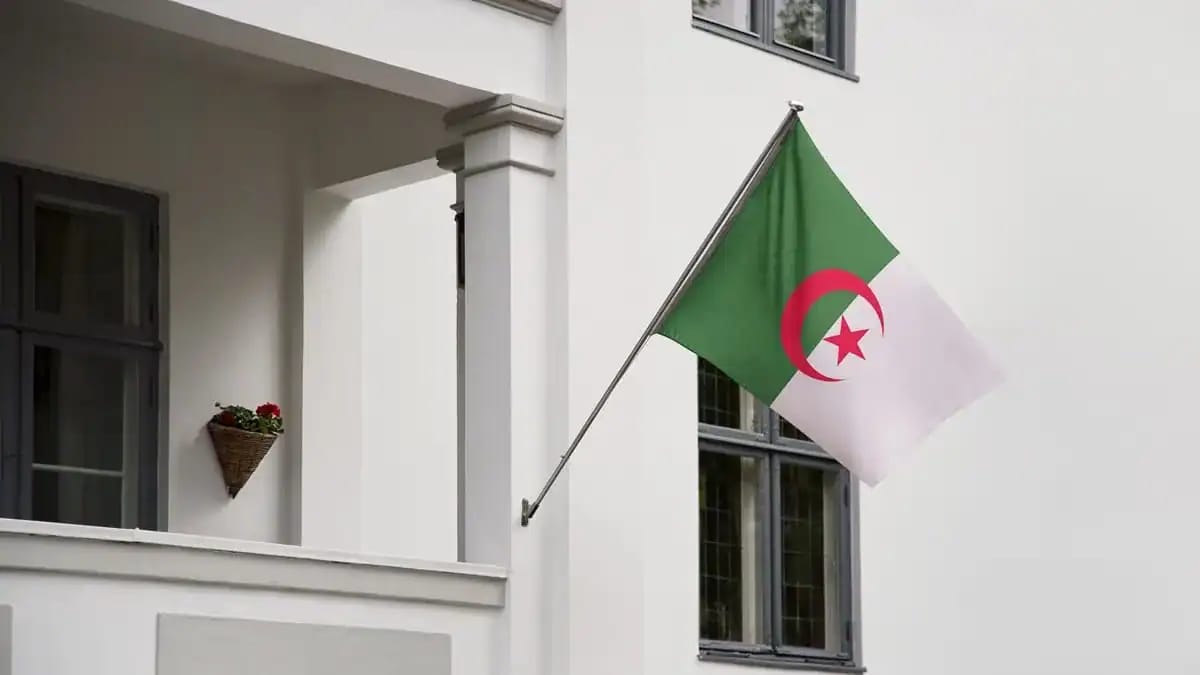 Drapeau algérien flottant devant un bâtiment en France.
