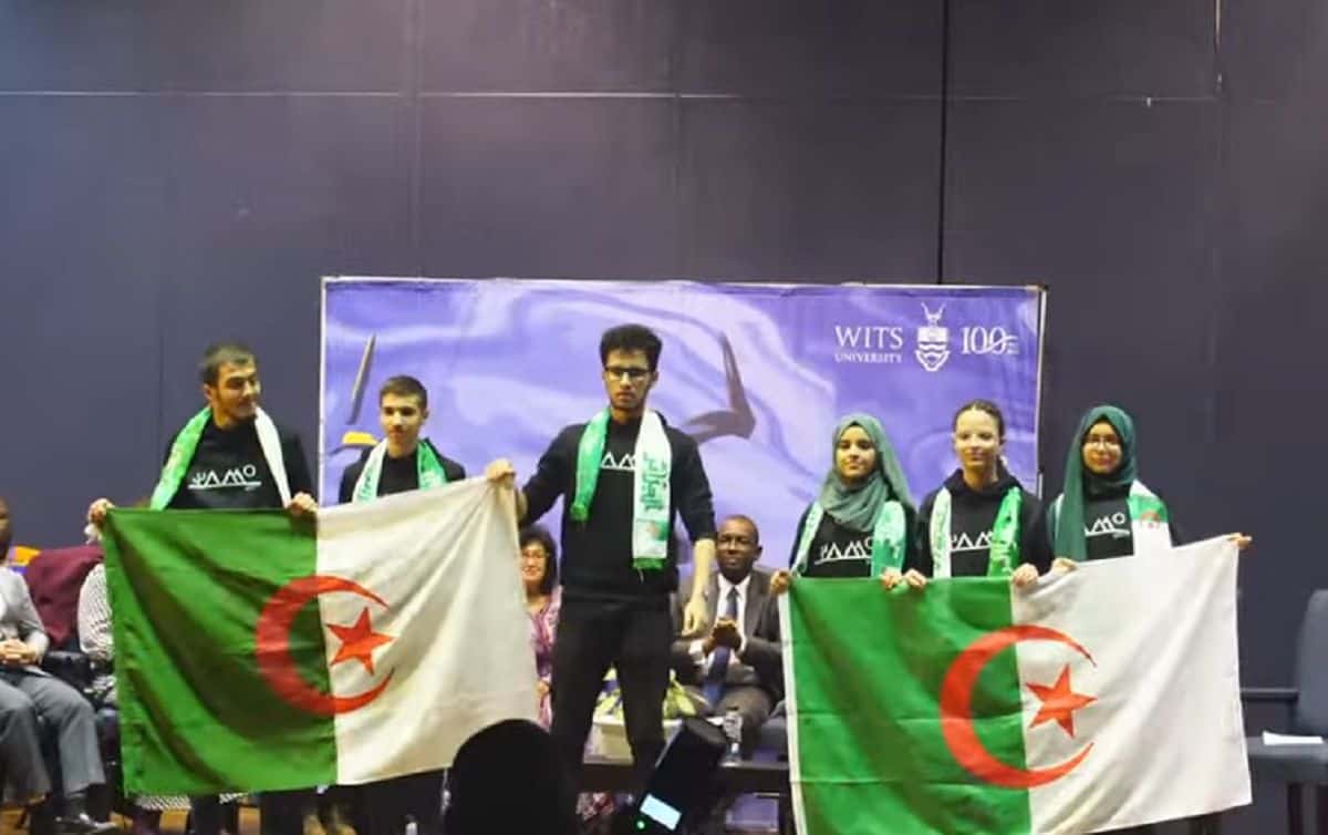 Jeunes prodiges algériens avec drapeaux lors d'une cérémonie.