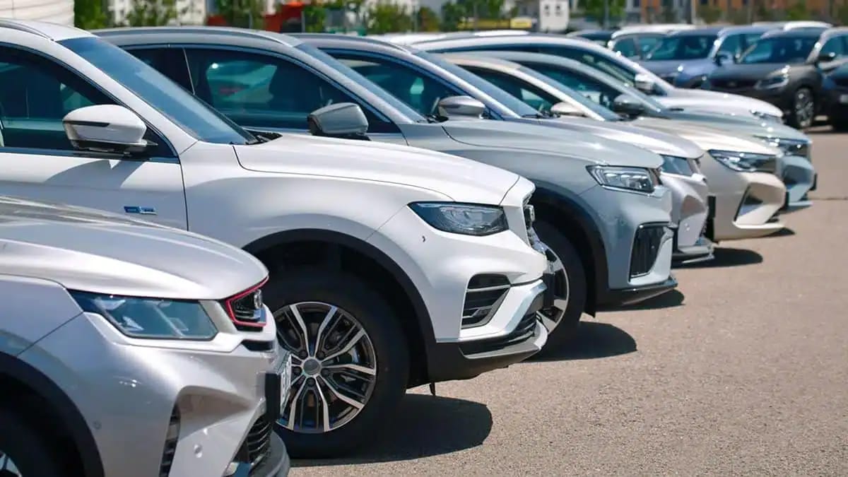 Voitures neuves alignées dans un parking en Algérie.