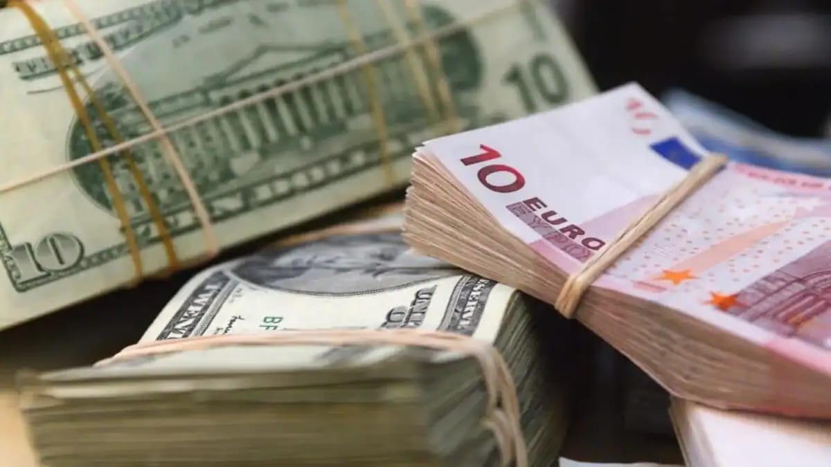 Billets de banque en euros et dollars, avec un dinar en arrière-plan.