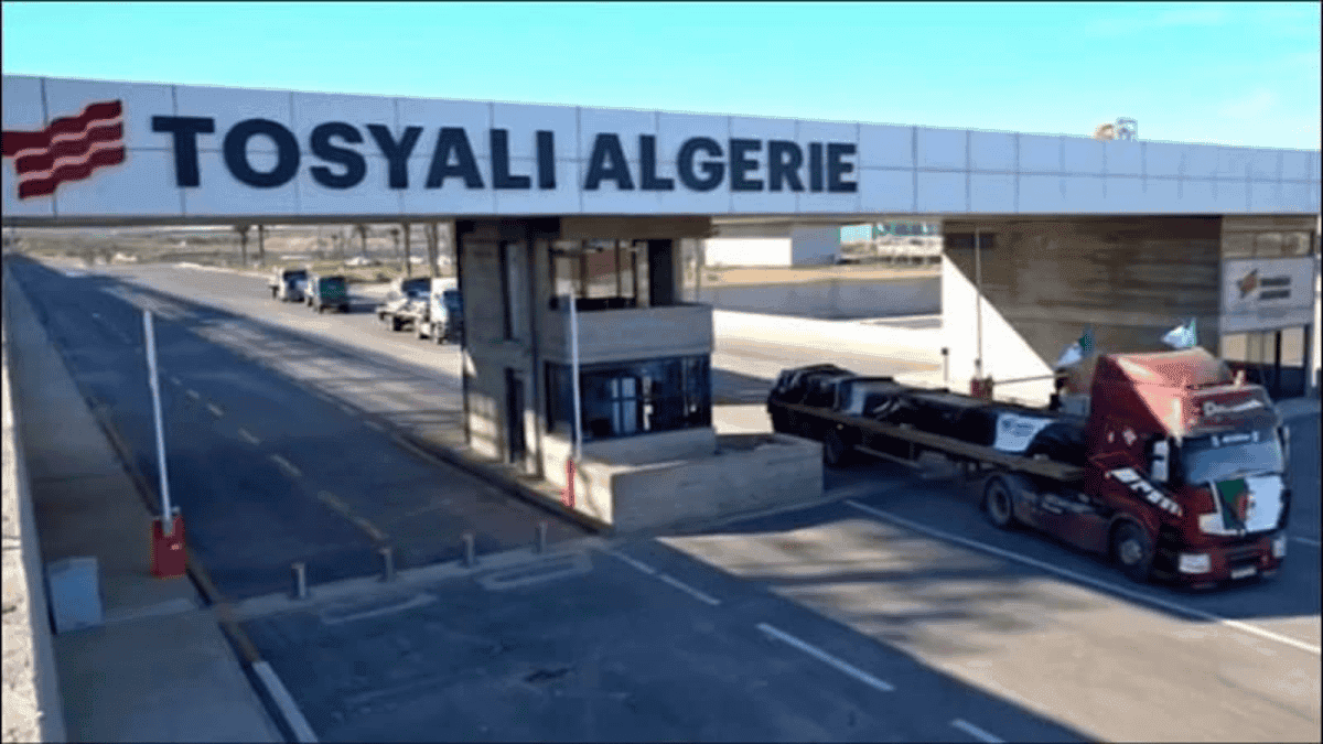 Porte d'entrée de l'usine Tosyali en Algérie avec camions de livraison.