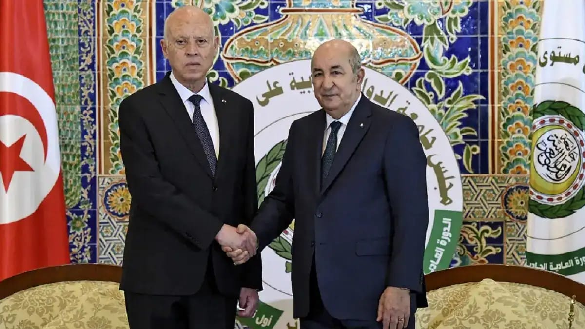 Deux hommes en costume se serrent la main lors d'une rencontre officielle.
