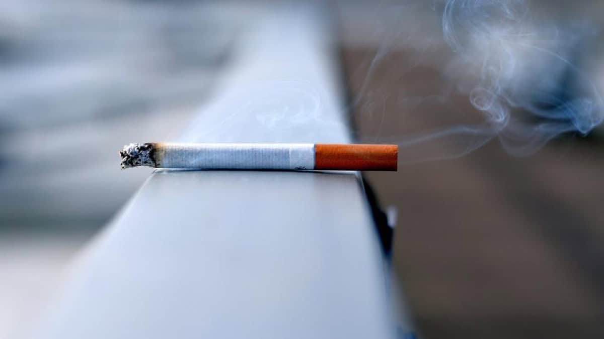 Cigarette en train de brûler avec de la fumée.