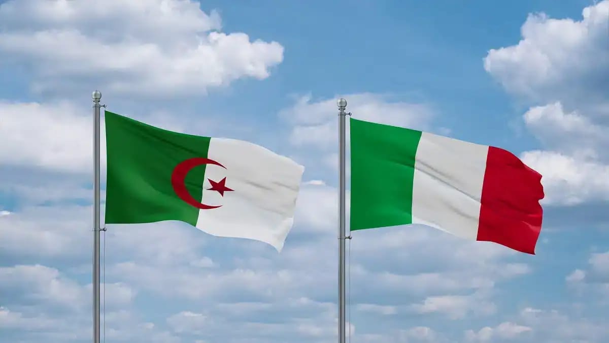 Drapeaux d'Algérie et d'Italie flottant dans le ciel.