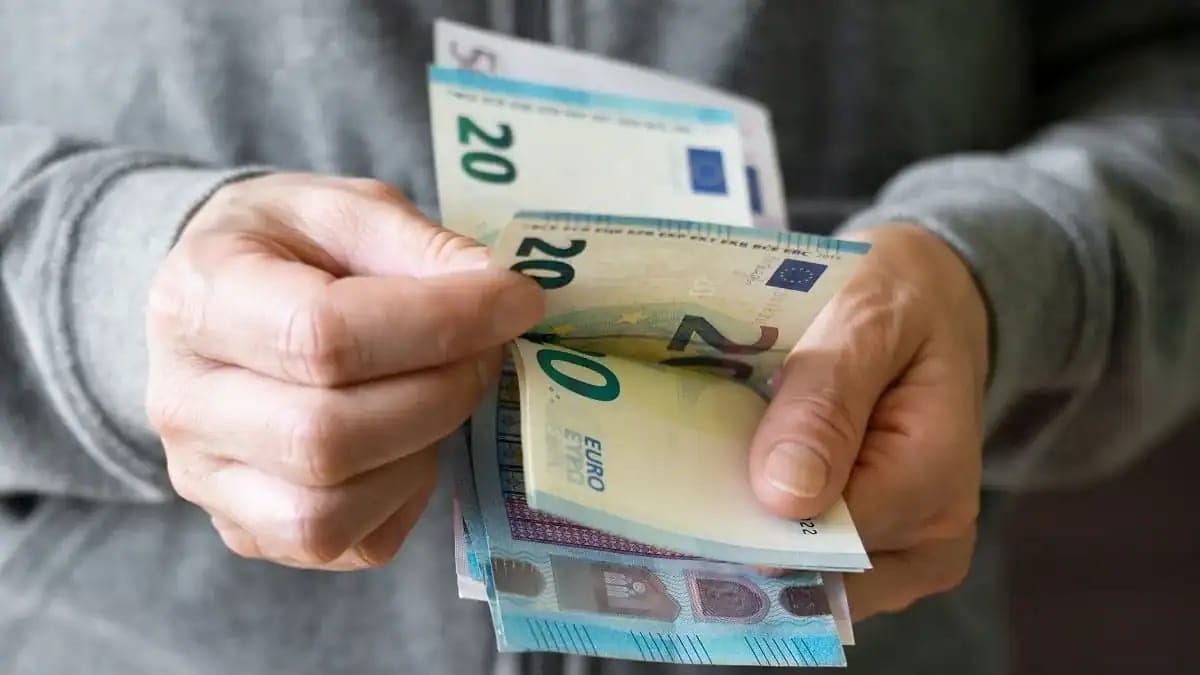 Hommes manipulant des billets d'euros dans une transaction.