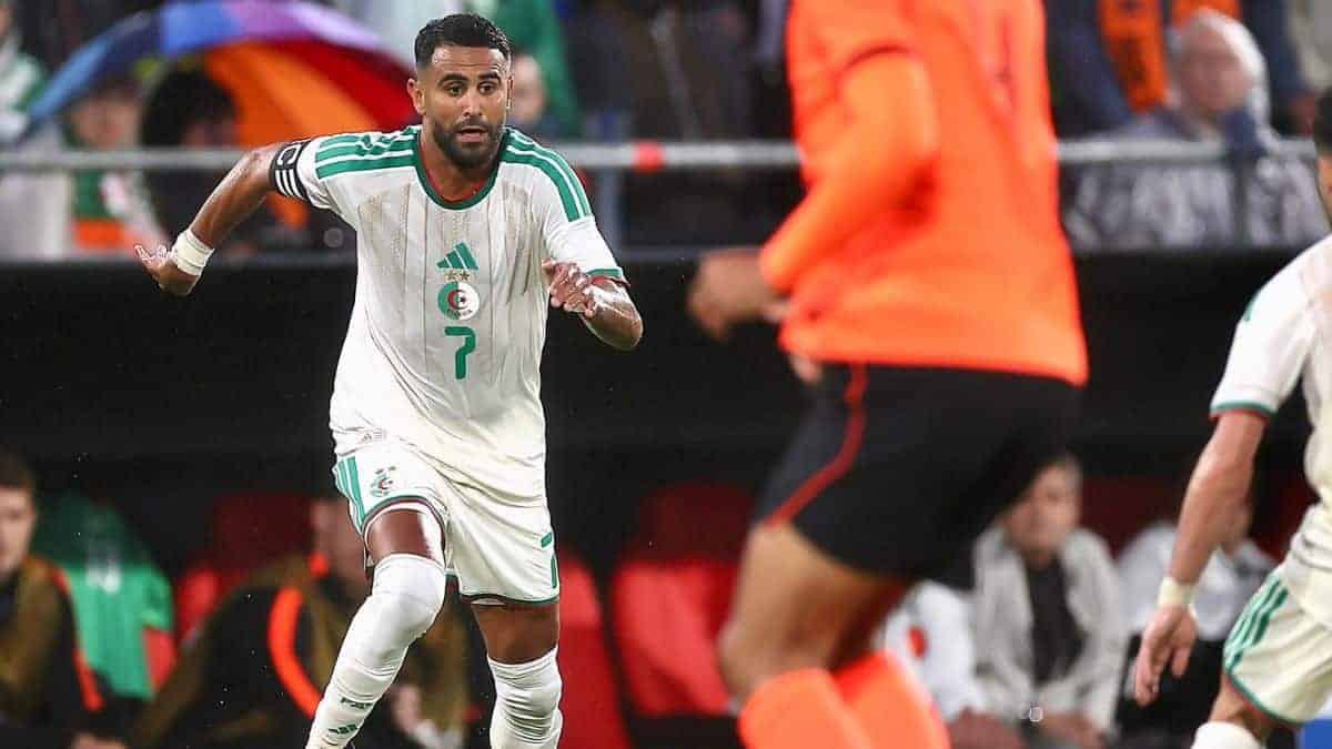 Hadj Moussa, joueur algérien, en pleine action sur le terrain de football.
