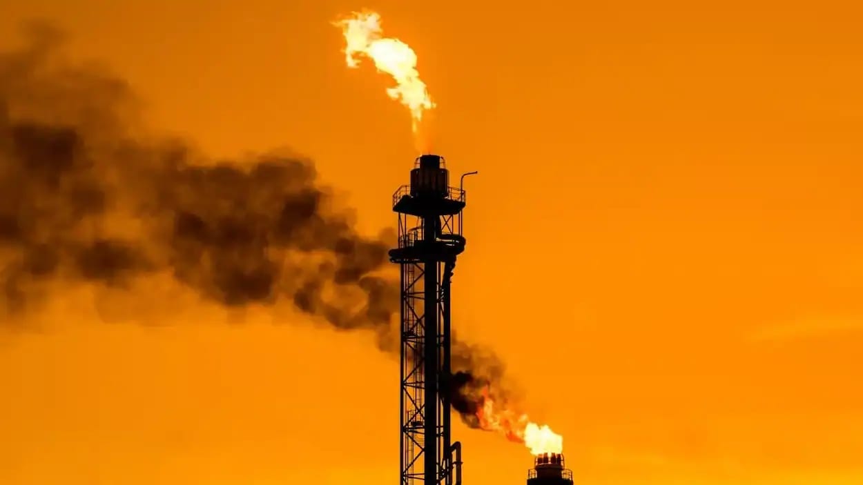 Tour de forage pétrolier avec fumée et flamme en Algérie.