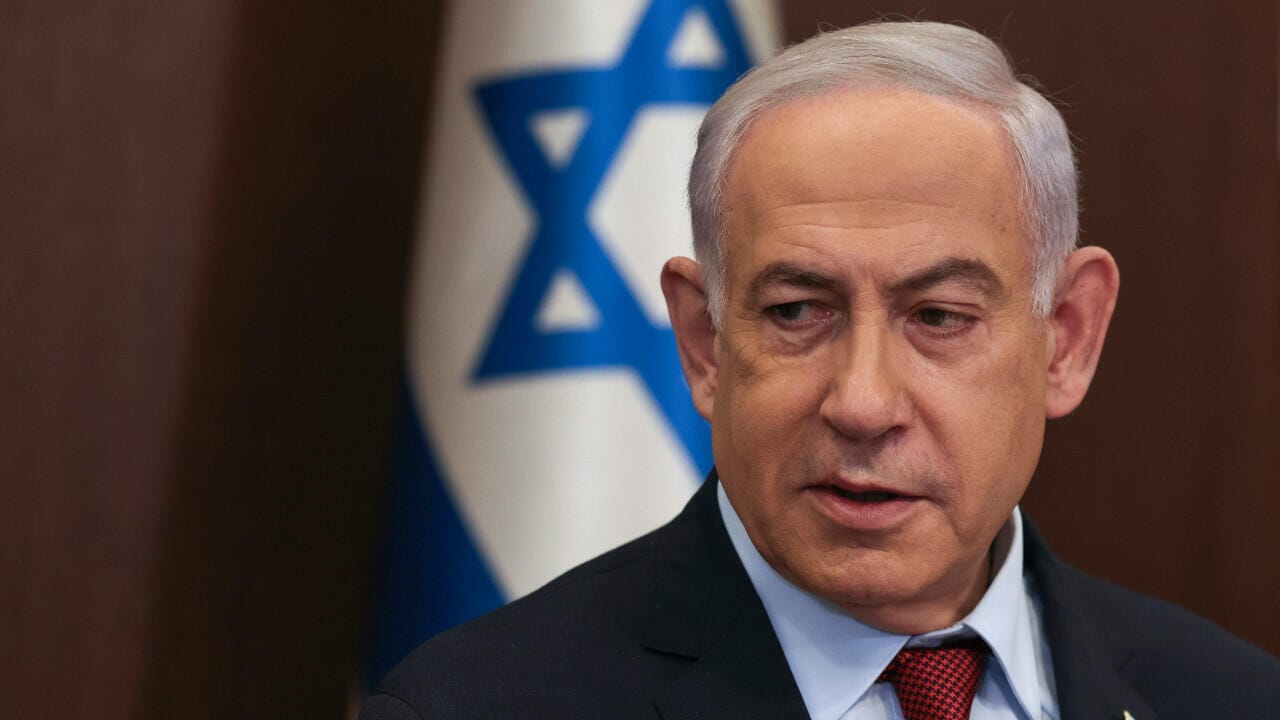 Premier ministre Netanyahu avec drapeau israélien en arrière-plan.