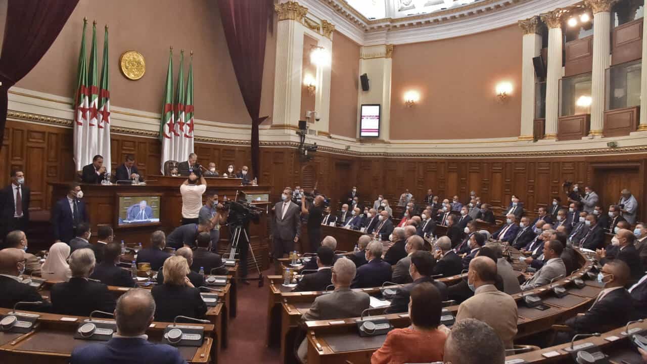 Débat politique en Algérie avec des représentants et un public nombreux.