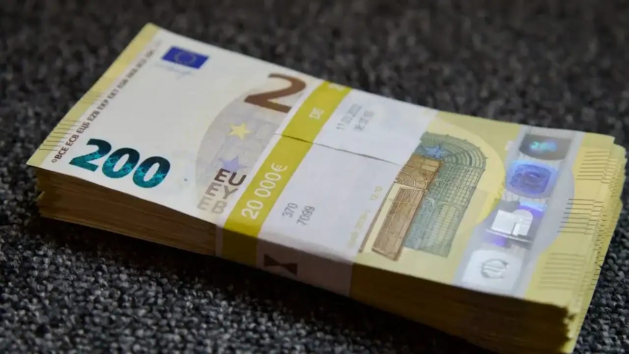 Billet de 200 euros sur une surface sombre, vue de face.