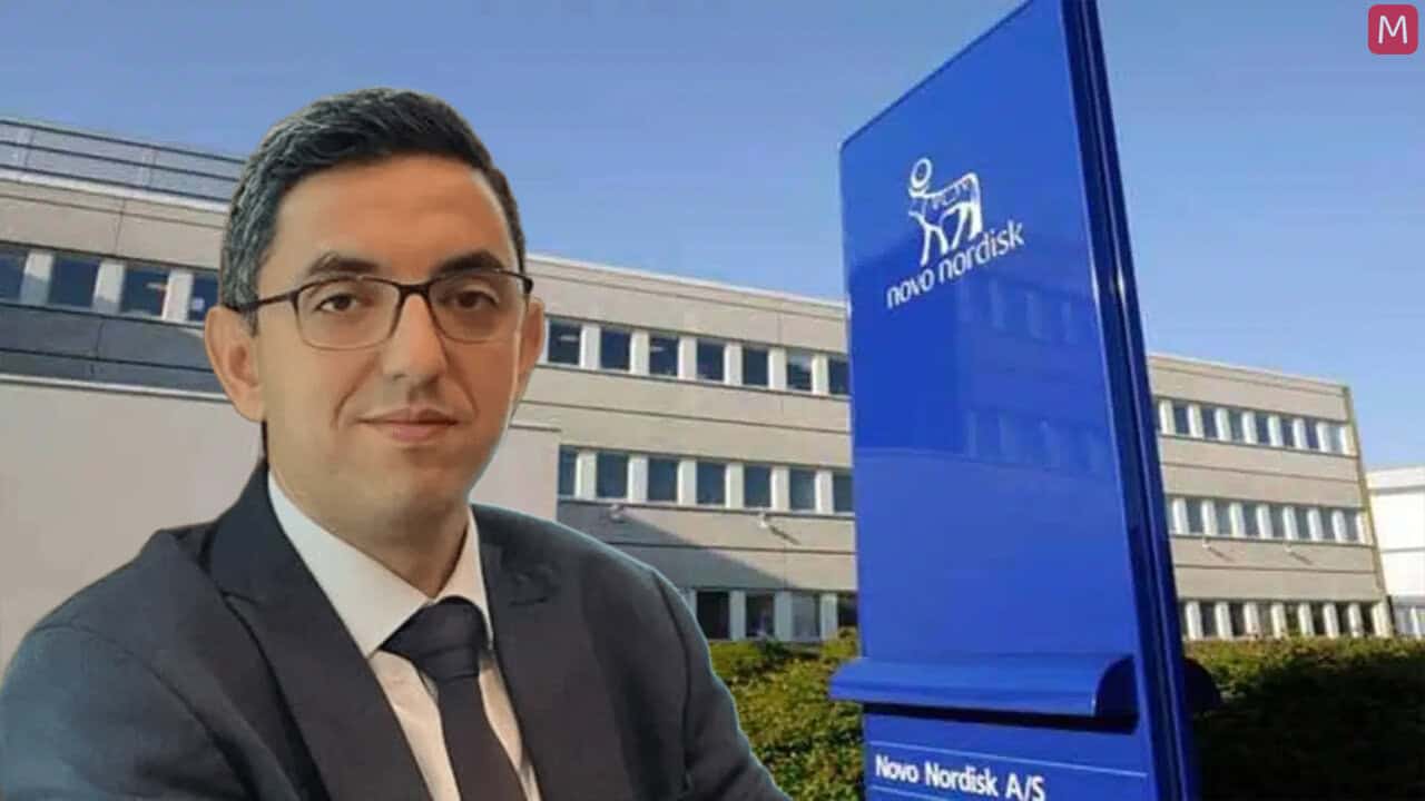 Homme d'affaires en costume devant le bâtiment Novo Nordisk.