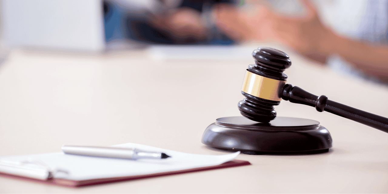 Bâton de juge et marteau dans une salle d'audience judiciaire.