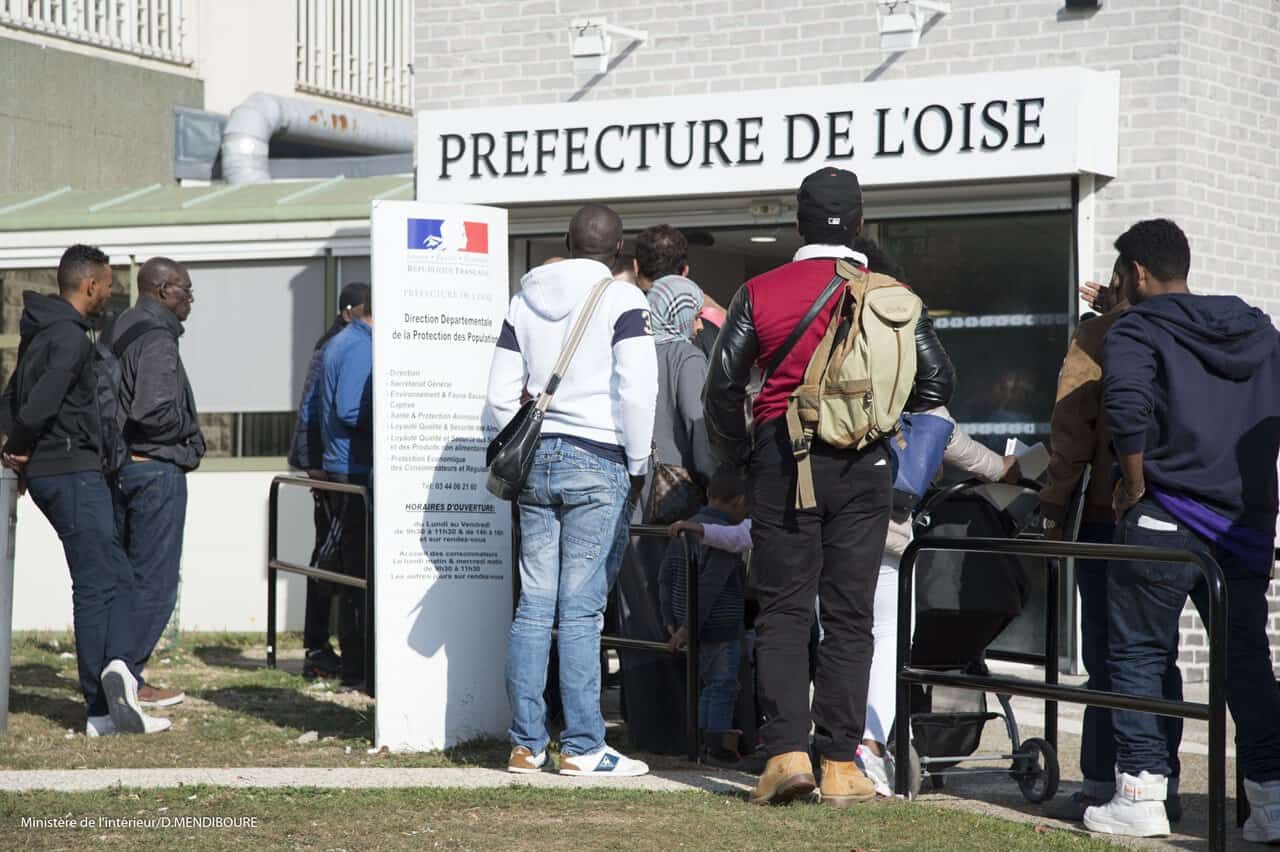 Gens faisant la queue à la préfecture de l'Oise pour démarches administratives.