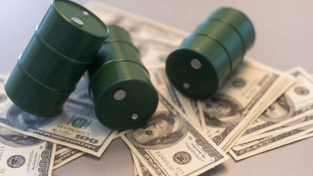 Barils de pétrole verts sur des billets de dollar américains.