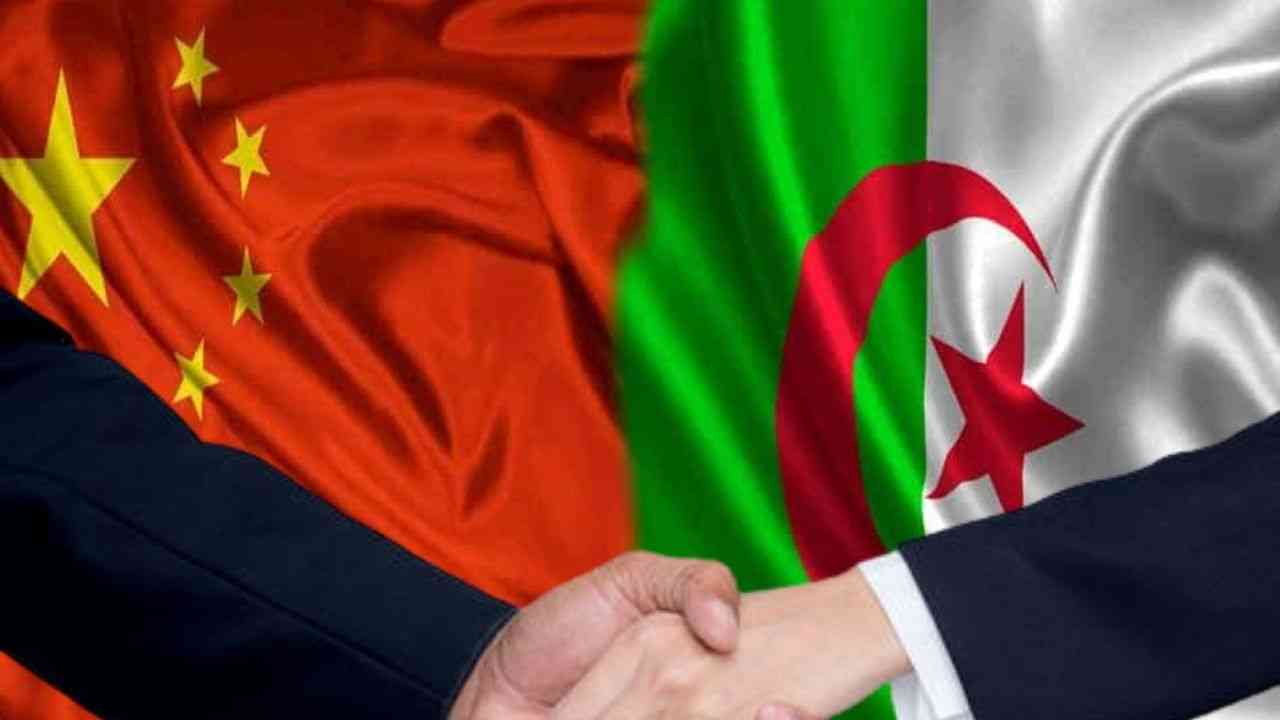 Poignée de main entre deux personnes avec drapeaux Algérie et Chine en arrière-plan.