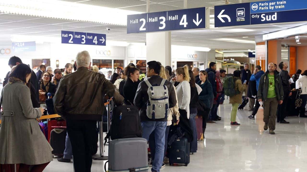Foule de passagers dans un aéroport parisien en période de grève.