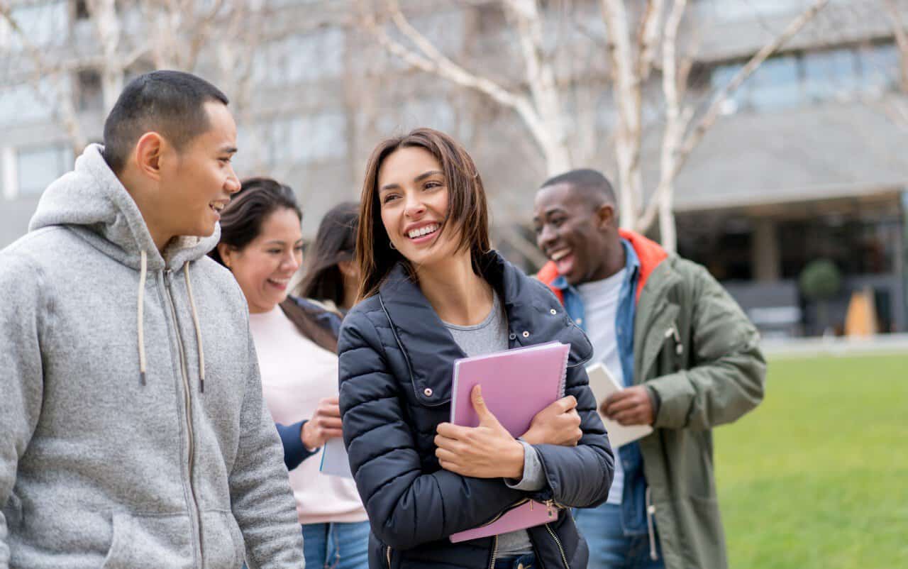 Groupe d'étudiants étrangers souriants en extérieur en France.
