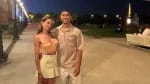 Jeune femme et homme souriants lors d'une promenade nocturne dans un parc.