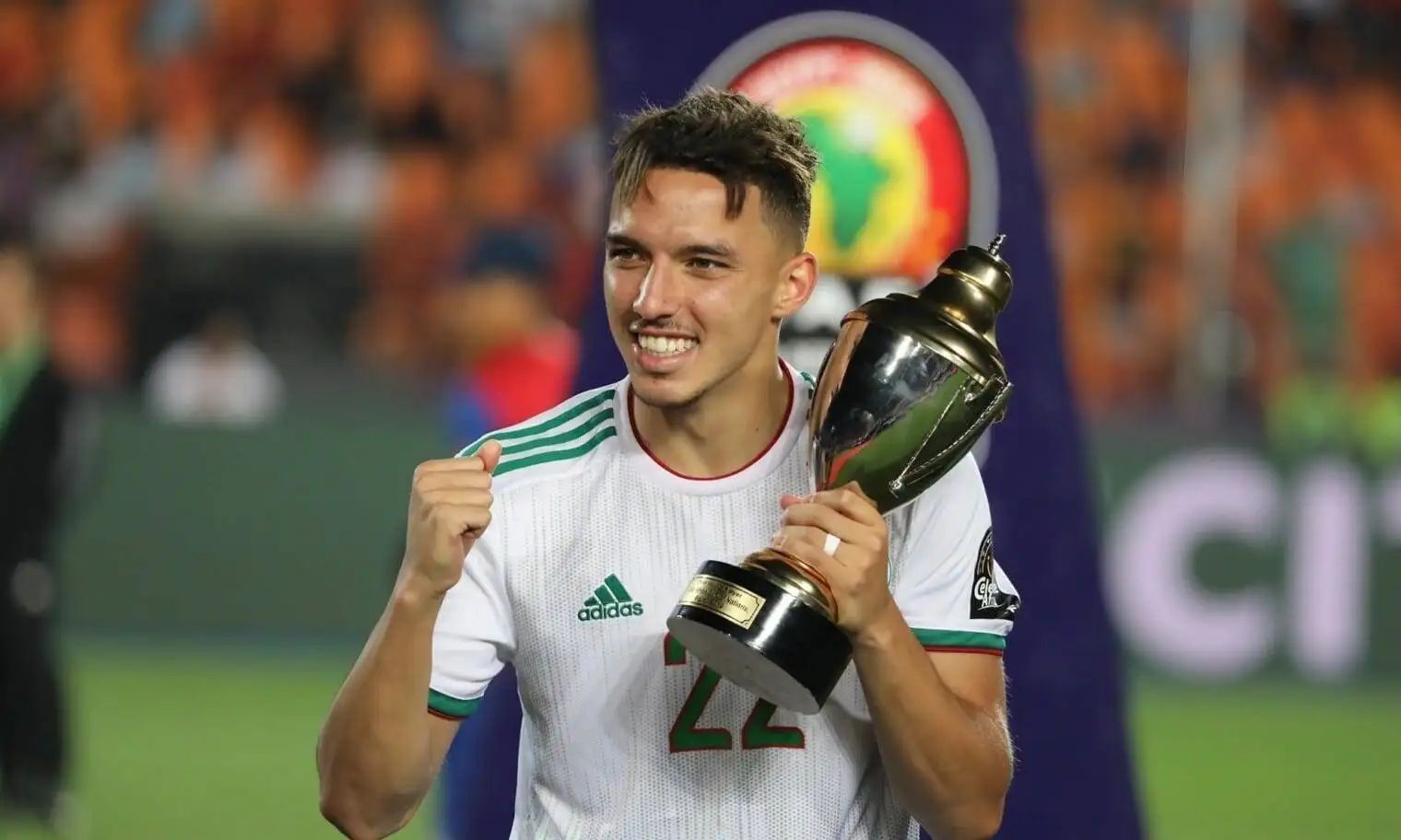 Ismaël Bennacer souriant avec le trophée de la CAN 2021.